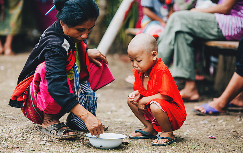 A child squats to eat FMSC food