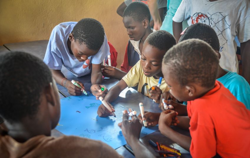 boys drawing with markers at a table