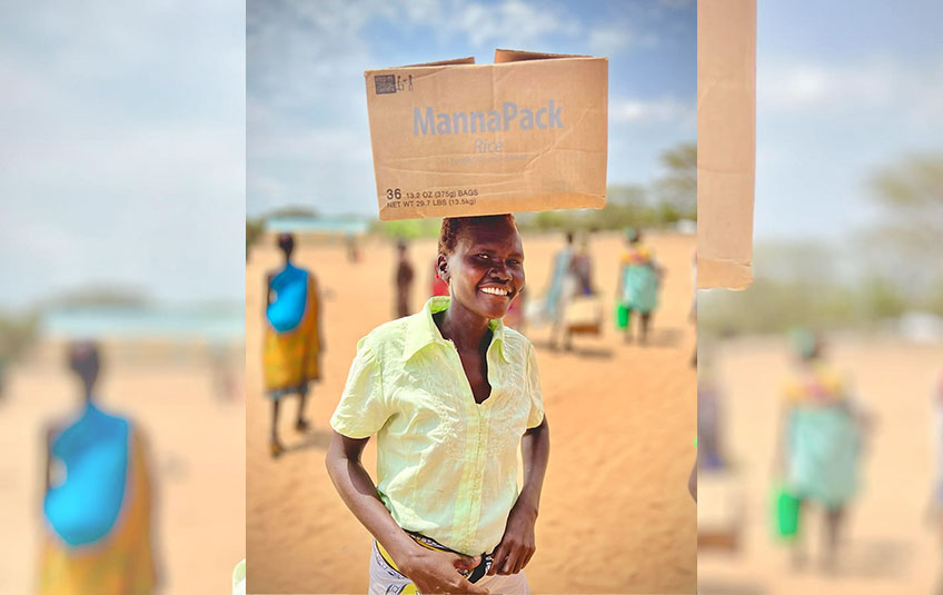 a person carrying a box of FMSC food on their head
