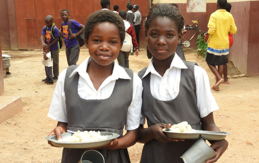 Two girls holding FMSC food in Zambia