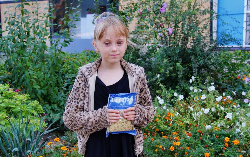 Ukrainian meal recipient holding MannaPack bag